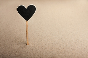 Fototapeta premium Pointer, ads board in the form heart in the sand