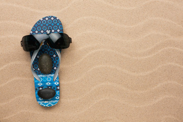 Concept of a man's face, flip-flops and sunglasses