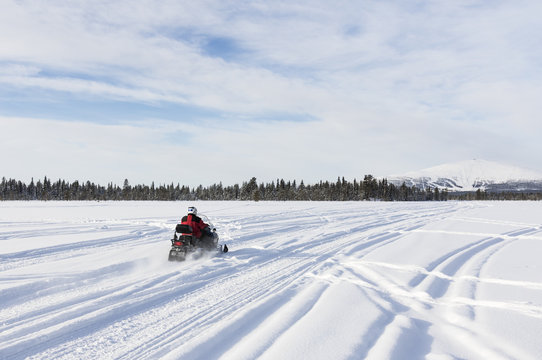 Going with snowmobile towards to mountain in Lapland