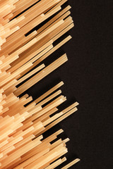 Raw Italian spaghetti pasta on black background