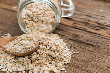 Dry rolled oat flakes oatmeal on old wooden table