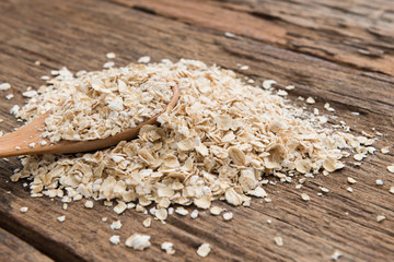 Dry rolled oat flakes oatmeal on old wooden table