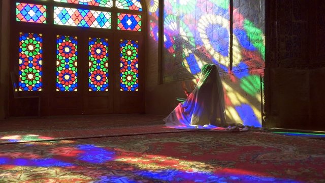 Young Muslim woman praying in Nasir Al-Mulk Mosque (Pink Mosque), Iran, Shiraz