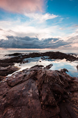 Cloud dramatic sunset and reflection on the water and rock at th