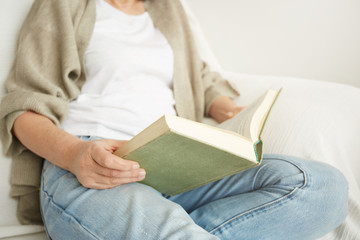 Charming mid age lady enjoying being at home and reading.