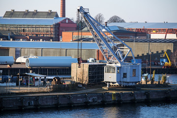 cargo port scene with an old dockyard crane on the pier.