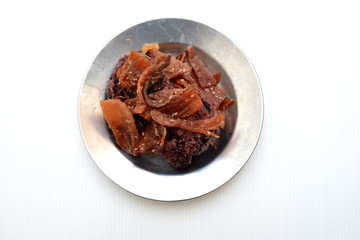 black sticky rice with fried sliced pork ,sesame , black pepper on metal dish