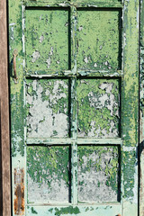 The old window with green closed shutters on an old house. Vinta