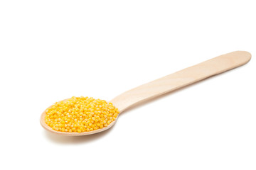 millet in a wooden spoon isolated