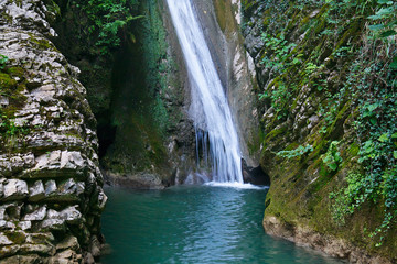 Obraz premium Beautiful waterfall in the forest among the gorge
