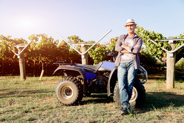 Obraz premium Man standing next to truck in vineyard