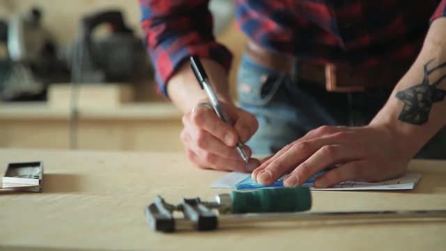 Man draws the drawing with a ruler