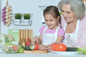 Senior woman with granddaughter cooking