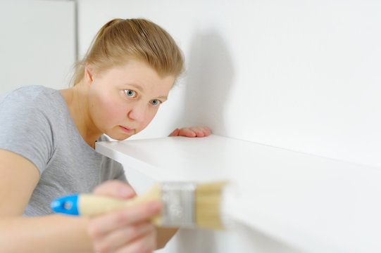 Photo of an attractive woman to paint a narrow shelf in the room