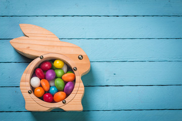 easter concept with colorful handmade eggs and rabbit on wooden table