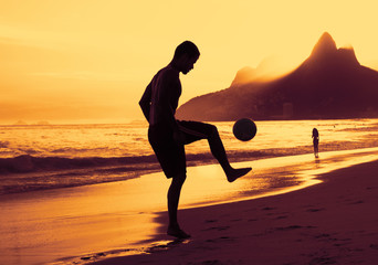 Spieler am Strand in Rio bei Sonnenuntergang