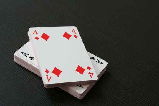 Four of tiles and ace of clubs on the top of the playing card deck