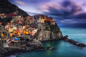 beautiful sunset over manarola in cinque terre, Italy. Sunlight lighting up the tips of the stormy clouds just before the night dawned. Manarola is a small coastal town in cinque terre, Italy.