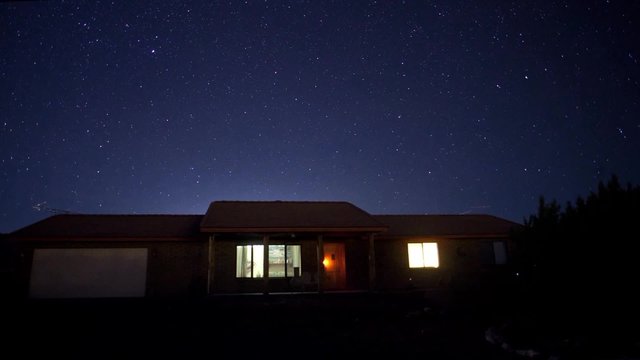 A time lapse of stars above a house at night