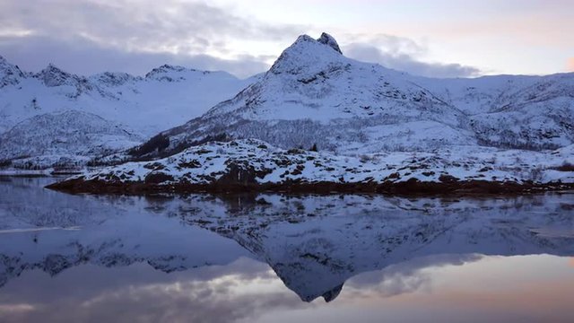 Snow covered mountains at a lake in the Lofoten islands region in Norway during winter