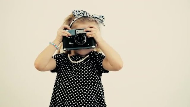 Vintage footage of pretty girl shooting with old camera of 80s. Concept of childhood and lifestyle.