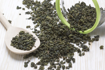 Spoon of dried green tea leaves