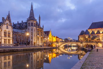 Naklejka na ściany i meble Picturesque medieval building and St Michael's Bridge on the quay Graslei in Leie river at Ghent town in the evening, Belgium