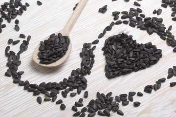 Sunflower heart shaped seeds and wooden spoon