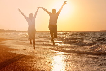 Happy couple running on the beach