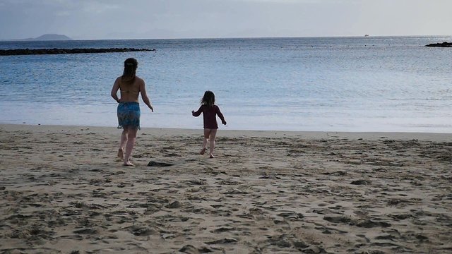 maman et sa fille courant sur la plage(slow motion)