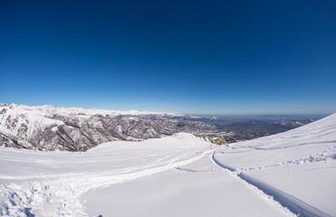 Fototapeta na wymiar Freeriding on fresh snowy slope, panoramic view, italian Alps