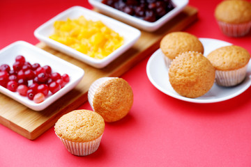 Muffins and jam on a red background