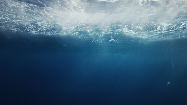 Beautiful underwater sea scene view with natural light rays, slow motion, the water glittering and have moving surface, caustics, bubbles, and foam, perfect for background and digital composition