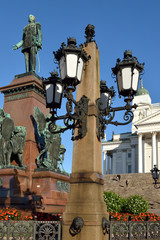Lanterns of monument of Emperor Alexander II are located in center of Senate Square in Helsinki - obrazy, fototapety, plakaty