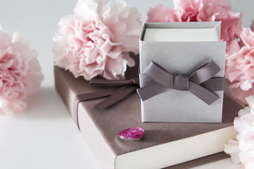 Gift box and carnation flowers on white background