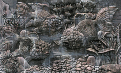 Fishes from stone panels on wall.