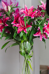 Bouquet of dark pink lilies in a glass vase