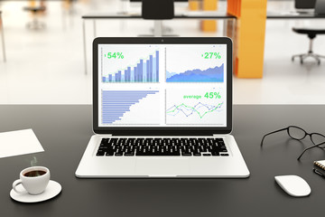 Fototapeta premium Financial statistics on laptop screen on black table with cup of