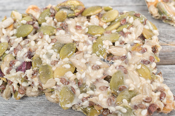 Delicious pieces of nougat with variety of dried nuts on wooden