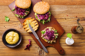 Burger with meat of duck with red onion and lettuce.