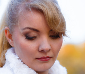 Sad woman spend time in autumnal park.