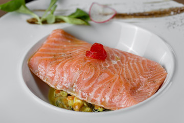 fish cooked with spices, butter and vegetables, lined in white plate