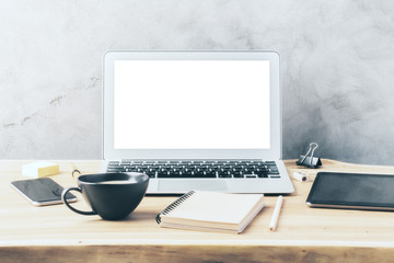 Blank laptop screen on a wooden slab with coffee cup, notebook a