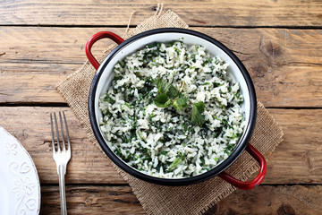 ortica,riso con foglie di ortica in tegame di metallo sfondo rustico