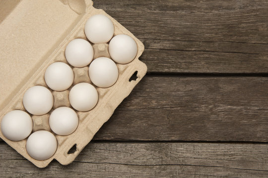 Carton of organic eggs on wooden background with instant photograph. Top view.