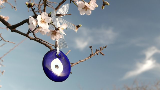Evil Eye Amulet Hangs on a Blossoming Tree. 4k