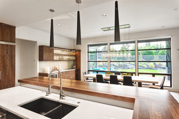 Kitchen in New Luxury Home with Two Islands, Two Sinks, Hardwood Floors, Elegant Cabinetry, Open Floor Plan with View of Dining Room and Outdoor Patio