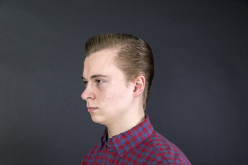 unhappy sixteen year old boy in studio