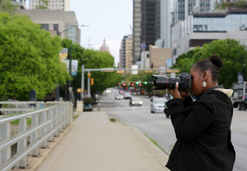 African-American woman-photographer is taking pictures on the street of Austin, TX