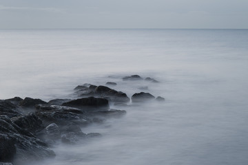 Stunning sunrise landscape over rocks in sea
